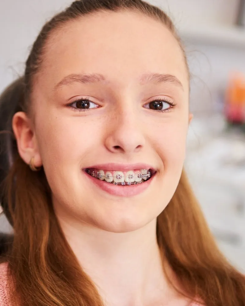 A smiling teenage girl wearing braces